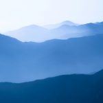 Layered blue mountain ridges in morning mist